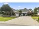 Charming brick home featuring a spacious driveway, manicured lawn, and beautifully landscaped garden beds at 5904 Bridlewood Rd., North Myrtle Beach, SC 29582