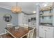 Dining area with wood table, white chairs, modern chandelier, and views into kitchen and living area at 5905 S Kings Hwy. # 416 A, Myrtle Beach, SC 29575