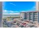 View of the building with a parking lot and a beach in the background on a bright, sunny day at 5905 S Kings Hwy. # 416 A, Myrtle Beach, SC 29575