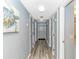 Hallway with gray walls, wood-style flooring, multiple white doors, and a turtle art piece hanging on the wall at 5905 S Kings Hwy. # 416 A, Myrtle Beach, SC 29575
