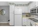 Well-lit kitchen with white cabinetry, appliances, tropical wallpaper and laminate countertop at 5905 S Kings Hwy. # 416 A, Myrtle Beach, SC 29575