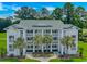 Inviting condo building featuring multiple stories, balconies, and lush landscaping with palm trees at 650 Tupelo Ln. # 5-F, Longs, SC 29568