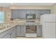 Well-lit kitchen featuring gray cabinets, stainless steel appliances, and granite countertops at 650 Tupelo Ln. # 5-F, Longs, SC 29568