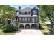 Charming two-story home with a covered front porch, a carport with swing and beautiful landscaping at 709 Triple Oak Ln., Garden City Beach, SC 29576