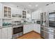 Well-lit kitchen boasts stainless steel appliances and white cabinetry, blending style with functionality for modern cooking at 709 Triple Oak Ln., Garden City Beach, SC 29576