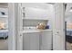 Convenient laundry area featuring a washer, dryer, storage cabinets, and easy access to the adjacent bedroom at 709 Triple Oak Ln., Garden City Beach, SC 29576