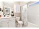 Bright bathroom with marble floors, white cabinetry and tub shower with patterned curtain at 800 Monarch Dr. # 49, Myrtle Beach, SC 29588