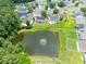 Aerial view of a pond with a fountain, surrounded by lush trees and well-maintained homes in a vibrant community at 805 Cherry Bark Ct., Myrtle Beach, SC 29579