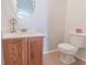 Charming half-bathroom features a classic vanity, an oval mirror, and a toilet, enhanced by neutral tones at 805 Cherry Bark Ct., Myrtle Beach, SC 29579