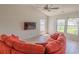 Bright living room features an orange couch, wood floors, ceiling fan and lots of natural light at 805 Cherry Bark Ct., Myrtle Beach, SC 29579
