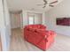 View of a living room with a large orange sofa, ceiling fan, and light wood flooring at 805 Cherry Bark Ct., Myrtle Beach, SC 29579