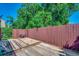 Backyard featuring a wooden deck, a red fence, and green foliage in the background at 808 Myrtle Ct. # 808, North Myrtle Beach, SC 29582