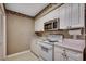Cozy kitchen featuring white cabinets, a stainless steel microwave, and a white electric range at 808 Myrtle Ct. # 808, North Myrtle Beach, SC 29582