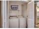 Compact laundry room featuring a washer, a dryer, and shelving for storage at 808 Myrtle Ct. # 808, North Myrtle Beach, SC 29582