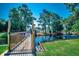 View of community pond with fountain featuring lush greenery, a small bridge and clear signage at 808 Myrtle Ct. # 808, North Myrtle Beach, SC 29582