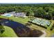 Aerial view showcasing the pool, clubhouse, and tennis courts in a lush, wooded setting at 81 Prestwick Dr., Pawleys Island, SC 29585