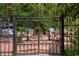 Ornate metal gate opens to a brick patio with seating, fireplace, and lush greenery at 81 Prestwick Dr., Pawleys Island, SC 29585