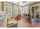 Bright sunroom with tiled floor, lots of windows with shutters, and cozy seating at 81 Prestwick Dr., Pawleys Island, SC 29585