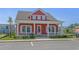Charming red home features a welcoming front porch, white trim, and manicured landscaping at 8148 Living Tide Dr., Myrtle Beach, SC 29572
