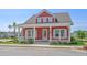 Charming red home features a welcoming front porch, white trim, and manicured landscaping at 8148 Living Tide Dr., Myrtle Beach, SC 29572