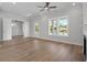 Open living room with hardwood floors, ceiling fan, and large windows offering plenty of light at 8148 Living Tide Dr., Myrtle Beach, SC 29572