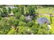 Aerial view of large house in wooded area with pond, golf course, and trees at 89 Cameron Ct., Pawleys Island, SC 29585