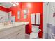 Bathroom featuring red accent wall, large mirror, and white vanity at 89 Cameron Ct., Pawleys Island, SC 29585