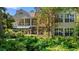 Exterior of home with a green awning and screened-in back porch surrounded by lush trees and greenery at 89 Cameron Ct., Pawleys Island, SC 29585