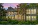 Exterior of home with a green awning and screened-in back porch surrounded by trees and greenery at 89 Cameron Ct., Pawleys Island, SC 29585