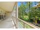 View from covered patio with metal railing overlooking manicured green lawn and wooded area, offering serene outdoor living at 89 Cameron Ct., Pawleys Island, SC 29585
