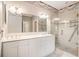 Bright bathroom with a tiled shower, a dual sink vanity, and a large mirror at 90 Old Carriage Ln., Pawleys Island, SC 29585