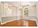 Open dining area with hardwood floors, an arched window, and elegant lighting fixtures at 90 Old Carriage Ln., Pawleys Island, SC 29585