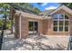 Brick home exterior with a patio, sliding glass door, and large window at 90 Old Carriage Ln., Pawleys Island, SC 29585