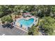 Aerial view of a sparkling community pool with ample seating, umbrellas, parking, and a charming pool house at 90 Old Carriage Ln., Pawleys Island, SC 29585