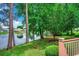 Backyard with lake view, trees and fountain, seen from a deck with wooden railing and yard at 911 Tilghman Forest Dr., North Myrtle Beach, SC 29582