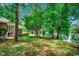 Picturesque backyard featuring mature trees, a well-maintained lawn, and a serene pond for relaxing and enjoying nature at 911 Tilghman Forest Dr., North Myrtle Beach, SC 29582