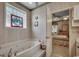 Bright bathroom featuring a jacuzzi tub, textured wallpaper, and an open door to a bedroom at 911 Tilghman Forest Dr., North Myrtle Beach, SC 29582