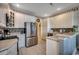 Well-lit kitchen with stainless steel appliances, white cabinets and a mosaic tile backsplash above the countertop at 911 Tilghman Forest Dr., North Myrtle Beach, SC 29582
