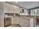 Bright kitchen with white cabinets, stainless dishwasher, countertop and view of the dining room at 911 Tilghman Forest Dr., North Myrtle Beach, SC 29582