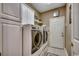 Modern laundry room with stainless steel washer and dryer set, white cabinetry, and tile floor at 911 Tilghman Forest Dr., North Myrtle Beach, SC 29582