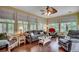 Bright living room featuring wood floors, comfortable seating, and many windows with a view of the surrounding yard at 911 Tilghman Forest Dr., North Myrtle Beach, SC 29582