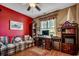 Comfortable living room features a cozy couch, red accent wall, and a charming home office setup at 911 Tilghman Forest Dr., North Myrtle Beach, SC 29582