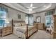 Spacious main bedroom with a tray ceiling, ceiling fan and a view of the yard through the many windows at 911 Tilghman Forest Dr., North Myrtle Beach, SC 29582