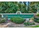 Welcoming entrance to the community with a decorative sign surrounded by colorful flowers and lush greenery at 911 Tilghman Forest Dr., North Myrtle Beach, SC 29582
