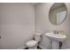 Powder room featuring a modern pedestal sink, round mirror and standard toilet at 960 Corn Husk Loop, Conway, SC 29527
