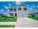 Charming two-story home featuring a manicured lawn, a two-car garage, and beautiful curb appeal under a bright sky at 960 Corn Husk Loop, Conway, SC 29527
