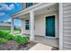 Charming home entrance with a covered porch, green door, and landscaping at 960 Corn Husk Loop, Conway, SC 29527