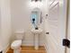 Charming powder room with pedestal sink, wood flooring, and modern fixtures at 974 Crooked Oak Dr., Pawleys Island, SC 29585