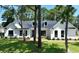 Charming white farmhouse with a black roof and lush landscaping at 974 Crooked Oak Dr., Pawleys Island, SC 29585