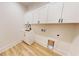 Well-lit laundry room features modern cabinetry, sink, and wood flooring at 974 Crooked Oak Dr., Pawleys Island, SC 29585